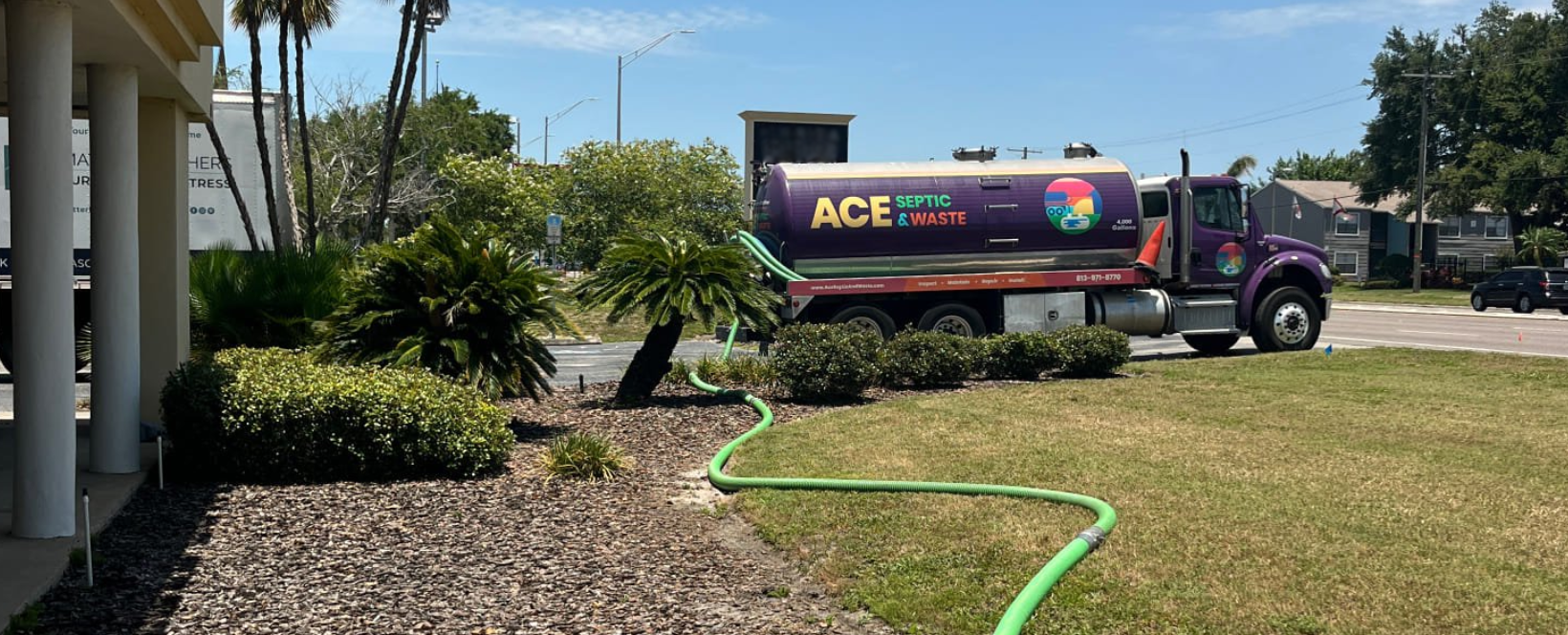 A septic truck pumping sewage with the hose extended from a Tampa Bay septic tank