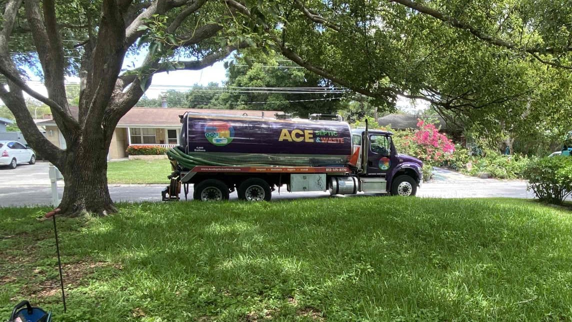 A branded septic pump truck on a residential property