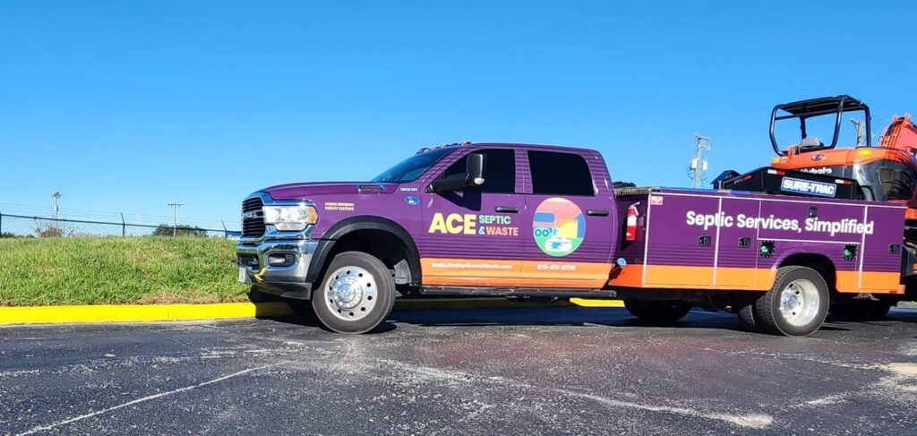 A branded septic truck with a backhoe in a trailer.